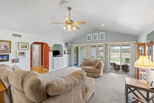 living room featuring carpet floors, visible vents, ceiling fan, high vaulted ceiling, and arched walkways