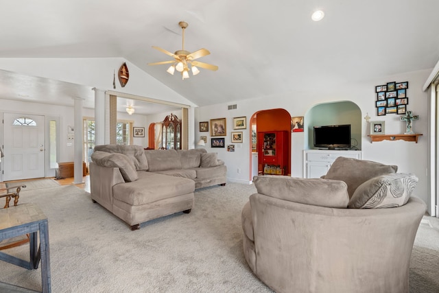 living area with a ceiling fan, arched walkways, visible vents, and light carpet