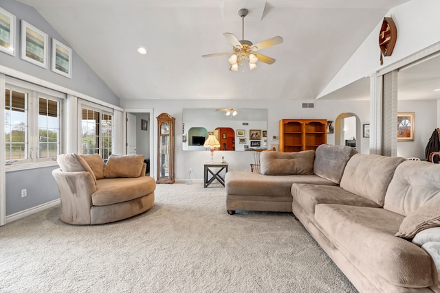 carpeted living area featuring a ceiling fan, arched walkways, visible vents, and baseboards