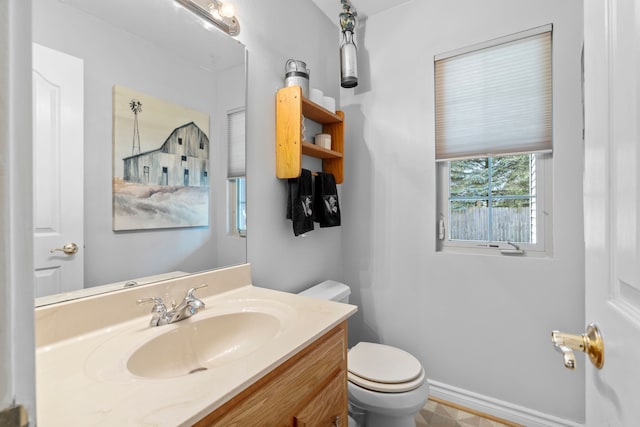 half bathroom featuring vanity and toilet