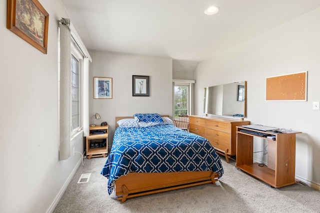 bedroom with baseboards, visible vents, and light colored carpet