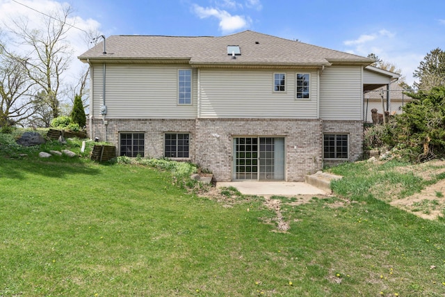 back of property featuring a lawn, a patio, and brick siding