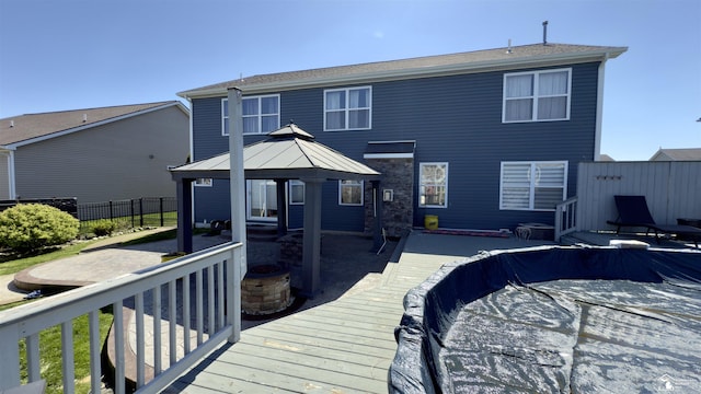 rear view of house with fence, a gazebo, and a patio area