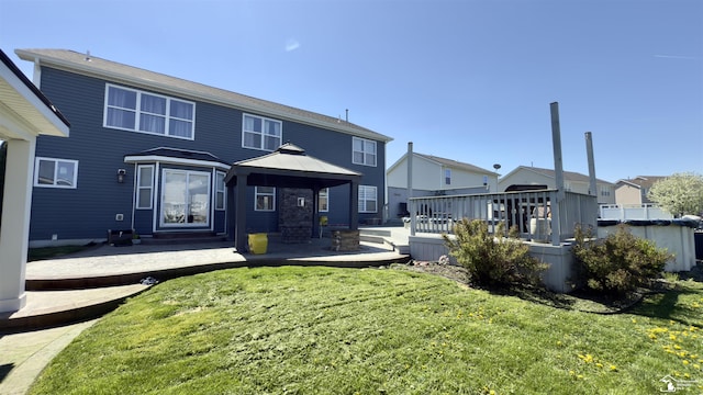 back of property with a residential view, a lawn, a deck, and a gazebo