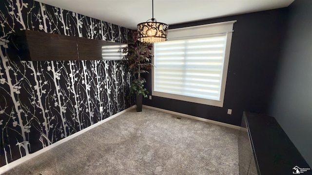 unfurnished dining area with a healthy amount of sunlight, wallpapered walls, carpet floors, and baseboards