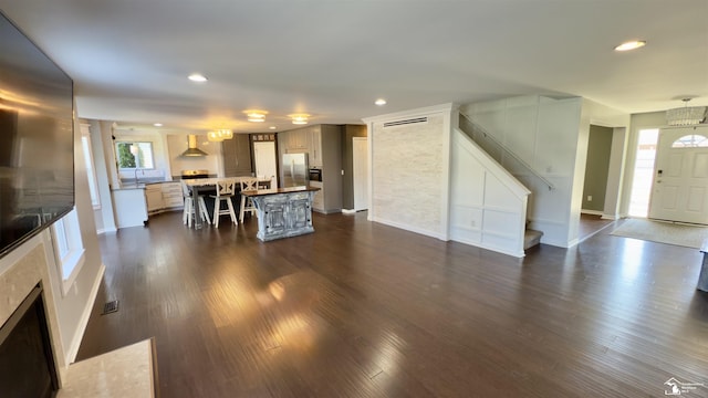living room featuring recessed lighting, stairs, and dark wood-type flooring