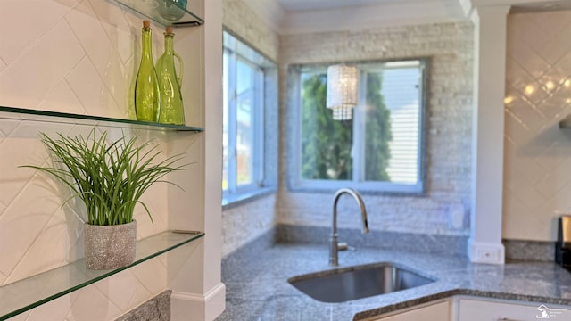 kitchen with a healthy amount of sunlight, stone counters, and a sink