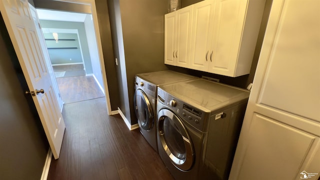 clothes washing area with dark wood-style floors, cabinet space, independent washer and dryer, and baseboards