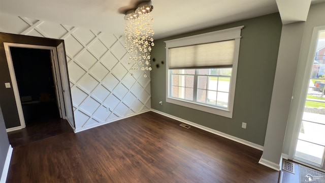 unfurnished dining area with dark wood-style floors, baseboards, and visible vents