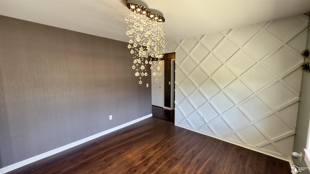 unfurnished dining area with baseboards, a notable chandelier, and dark wood-type flooring