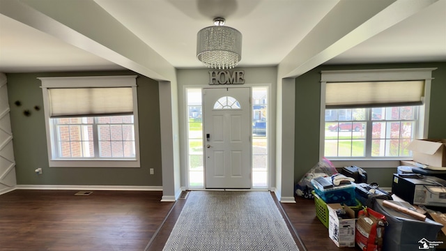 entryway featuring an inviting chandelier, dark wood-type flooring, and baseboards