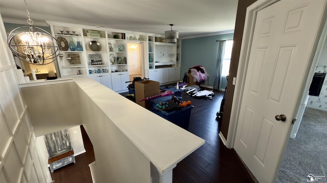 interior space featuring a chandelier, ornamental molding, dark wood finished floors, and baseboards