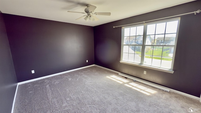 carpeted empty room with a ceiling fan and baseboards
