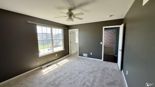 unfurnished bedroom with baseboards, visible vents, ceiling fan, and carpet