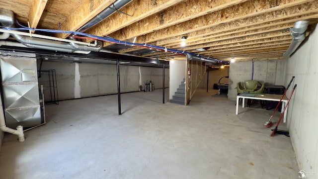 unfinished basement with heating unit and stairs