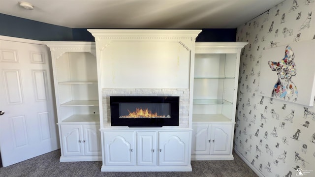 interior space featuring a glass covered fireplace and carpet flooring