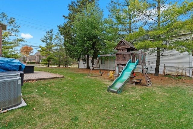 view of play area with fence, a yard, and cooling unit