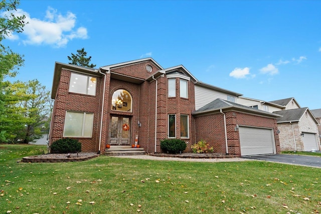 traditional-style home with a garage, aphalt driveway, a front lawn, and brick siding