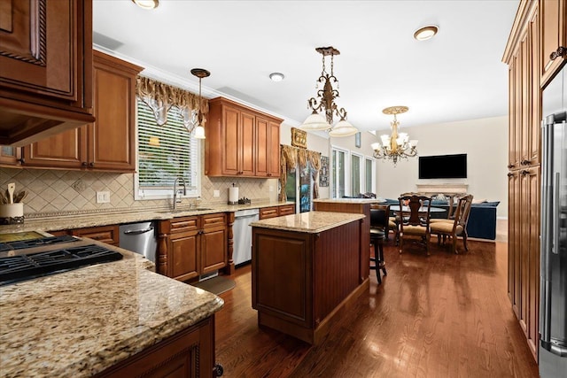 kitchen featuring dark wood-style flooring, a notable chandelier, appliances with stainless steel finishes, a sink, and a kitchen island