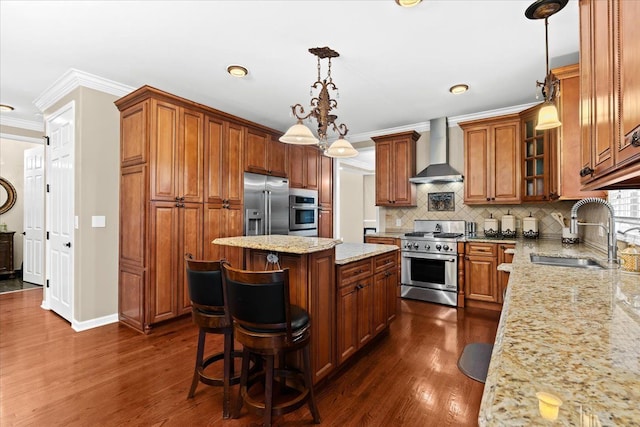 kitchen featuring wall chimney range hood, a sink, a center island, high end appliances, and ornamental molding