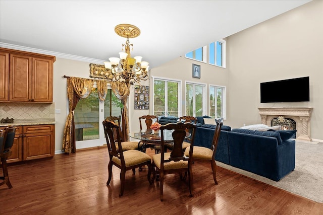 dining space featuring dark wood-type flooring, a warm lit fireplace, and a chandelier