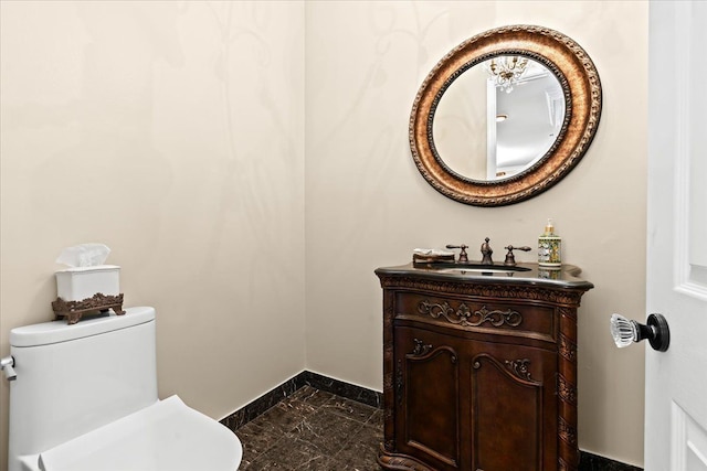 bathroom with baseboards, vanity, toilet, and marble finish floor