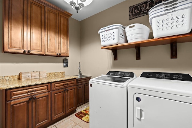 laundry room with cabinet space, independent washer and dryer, and light tile patterned flooring
