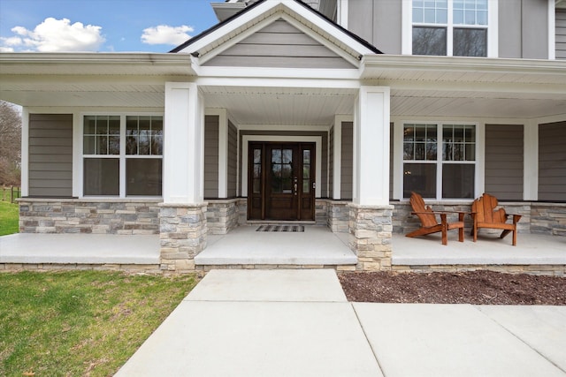 property entrance with covered porch, board and batten siding, and stone siding