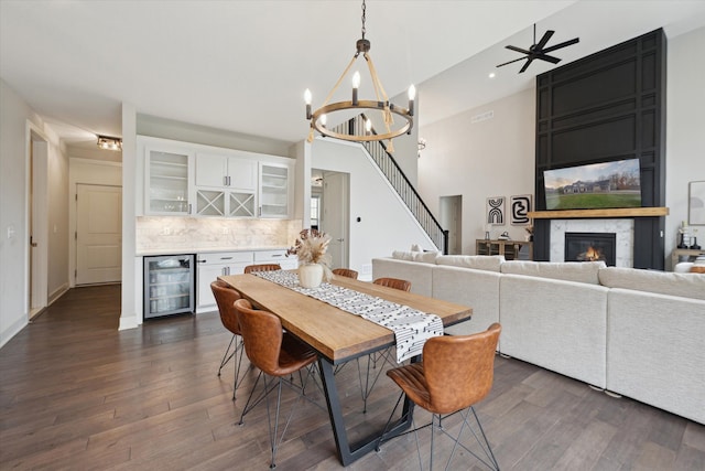 dining room featuring a dry bar, dark wood-style flooring, wine cooler, and a fireplace