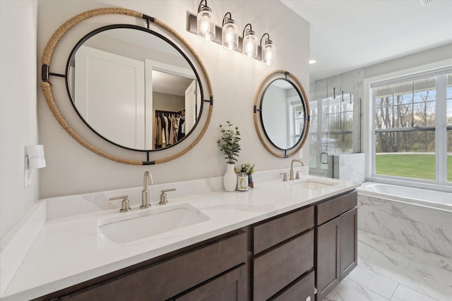 bathroom with a garden tub, double vanity, marble finish floor, an enclosed shower, and a sink