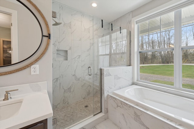 bathroom featuring marble finish floor, a marble finish shower, a bath, and a wealth of natural light