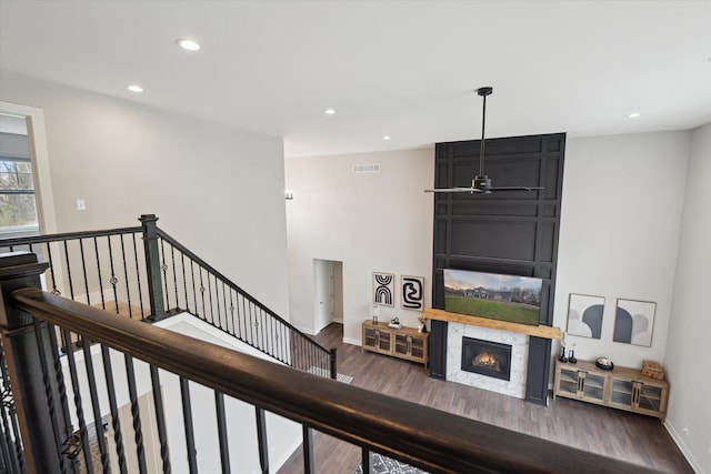 stairs featuring visible vents, a fireplace, wood finished floors, baseboards, and recessed lighting