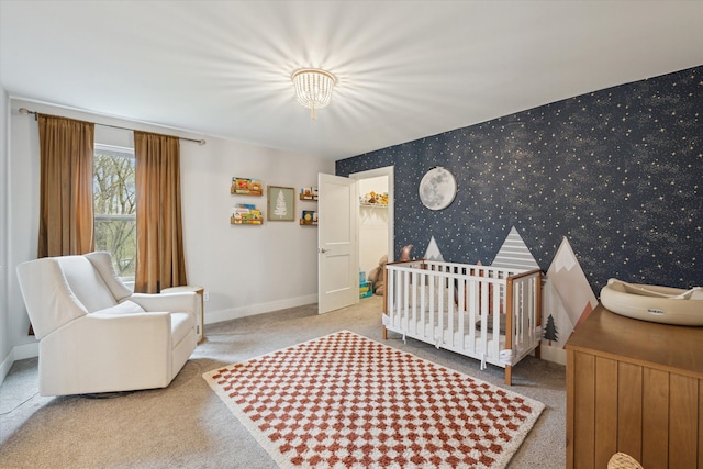 bedroom featuring wallpapered walls, a crib, baseboards, and carpet