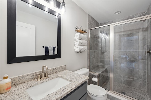 bathroom featuring vanity, a stall shower, and toilet