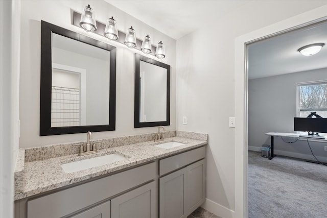 bathroom with baseboards, a sink, and double vanity
