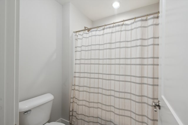 full bath with toilet and a shower with curtain