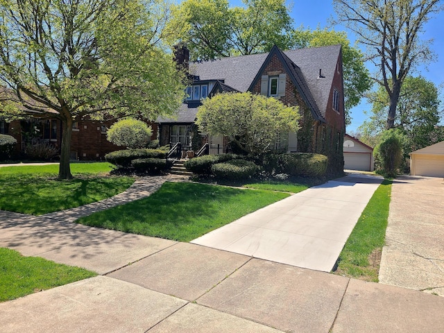 view of front of property featuring a front yard, a garage, and brick siding