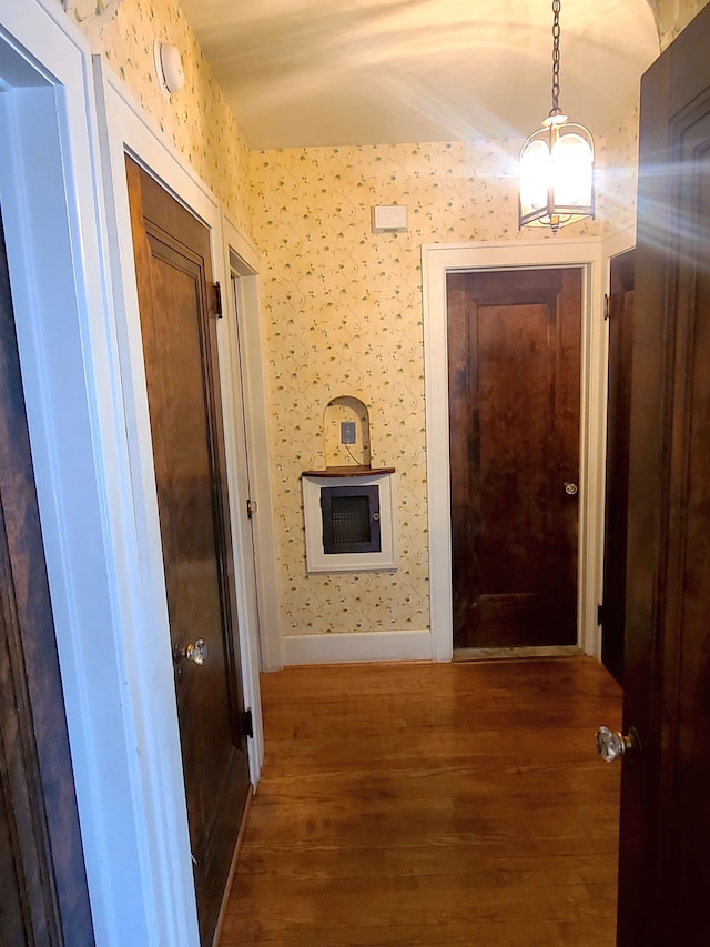 hallway featuring wood finished floors and baseboards