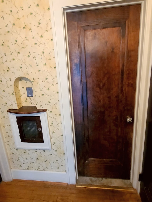 details featuring wood finished floors, wallpapered walls, and baseboards