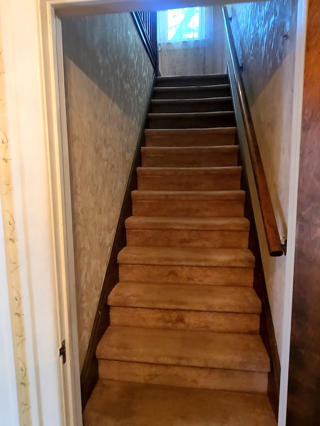 staircase featuring wallpapered walls and log walls