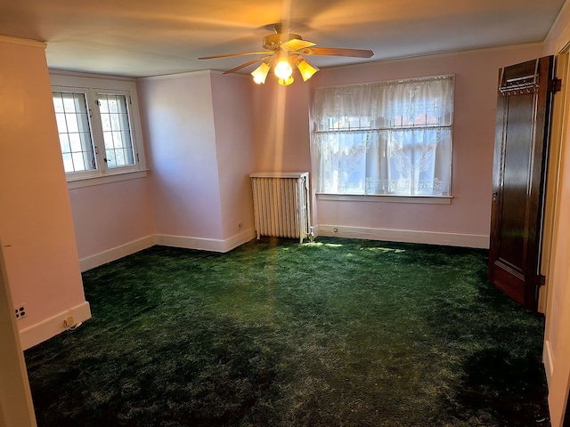 carpeted empty room with baseboards, a ceiling fan, and crown molding