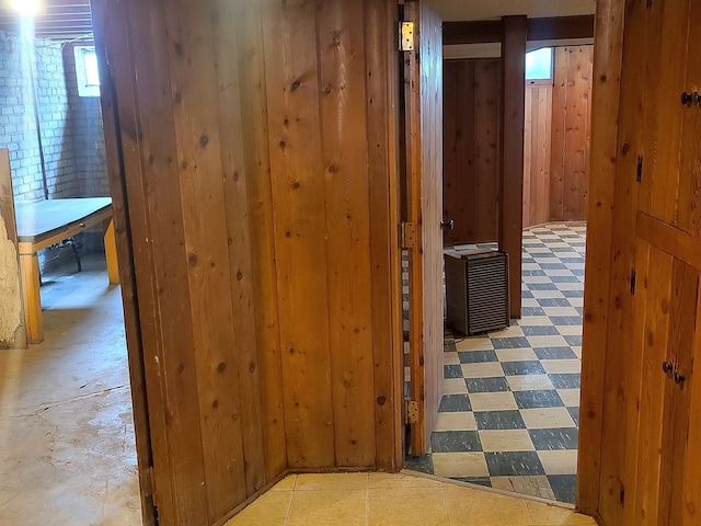 hallway featuring tile patterned floors and wooden walls