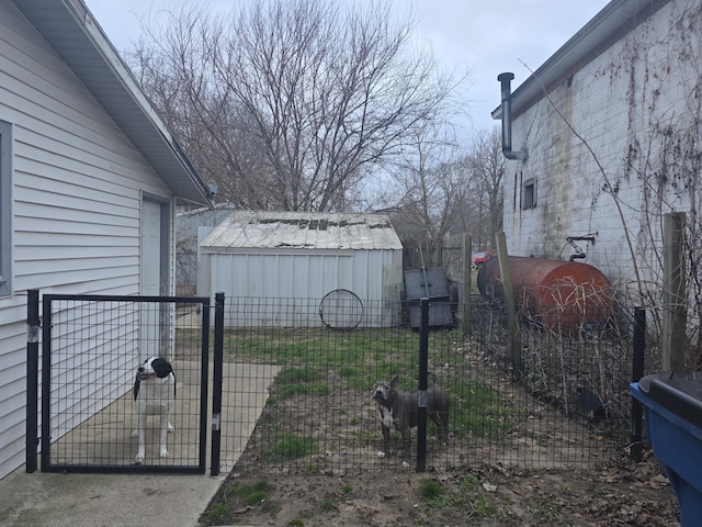exterior space with a gate, fence, an outdoor structure, and a shed