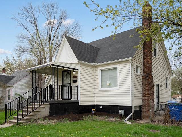 22625 Oaklane St, Warren, MI 48089 - exterior space with covered porch, fence, a chimney, and roof with shingles