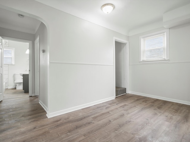 22625 Oaklane St, Warren, MI 48089 - spare room with arched walkways, baseboards, and wood finished floors