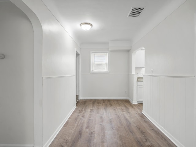 22625 Oaklane St, Warren, MI 48089 - spare room with arched walkways, visible vents, wainscoting, and wood finished floors