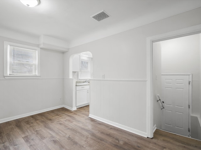 22625 Oaklane St, Warren, MI 48089 - unfurnished room featuring arched walkways, a wainscoted wall, wood finished floors, and visible vents