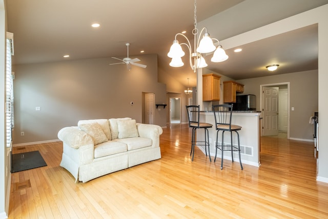 living area with baseboards, ceiling fan with notable chandelier, light wood finished floors, lofted ceiling, and recessed lighting