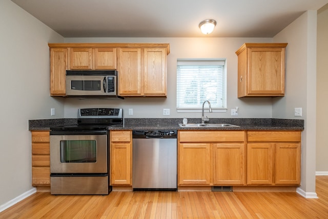 kitchen featuring a sink, stainless steel appliances, light wood-type flooring, and visible vents