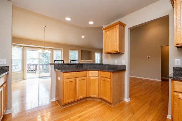 kitchen with baseboards, a peninsula, a chandelier, light wood-style floors, and recessed lighting